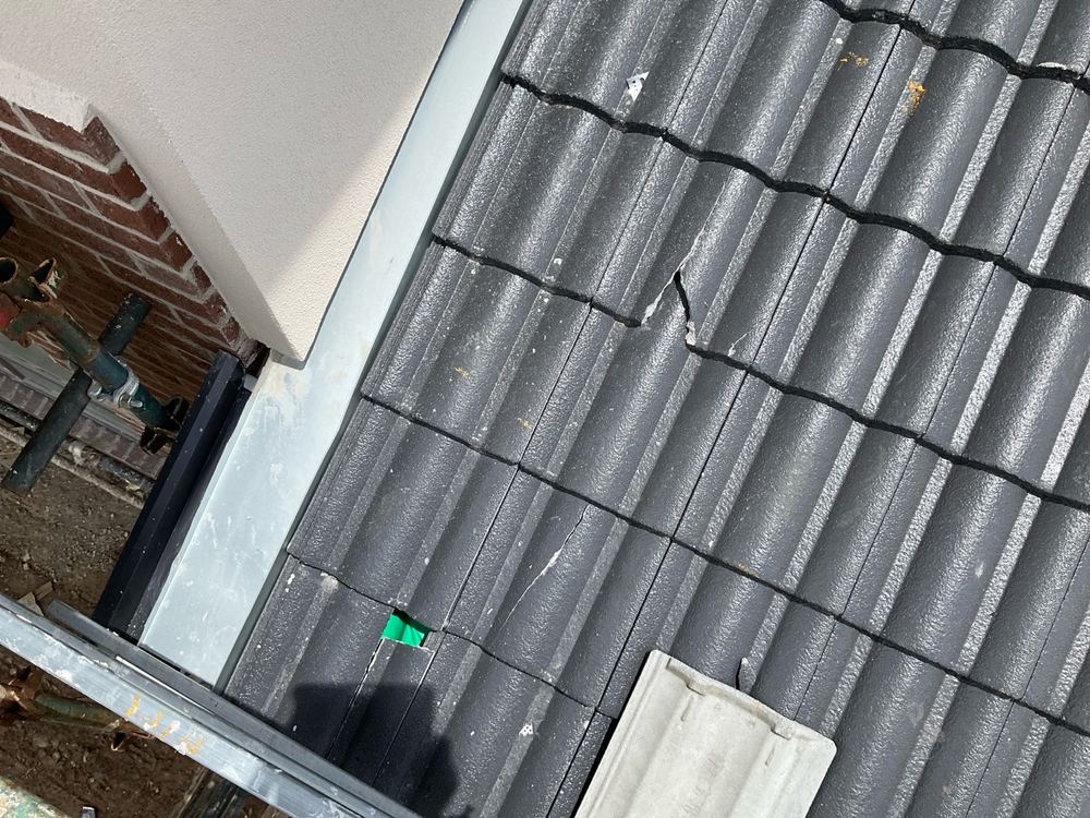 Cracked roof tile that needs replacing before rain gets underneath, found during a fixing inspection in Officer