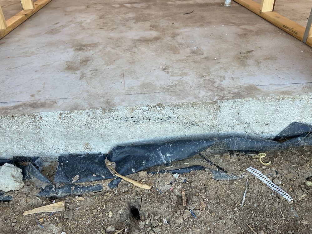 Honeycombed concrete along the slab edge, which can weaken it and let moisture in, found during a frame inspection in Officer